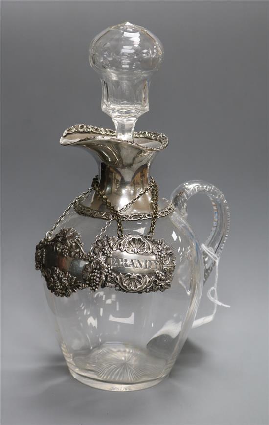 An Edwardian silver mounted glass claret jug & stopper, William Comyns, London, 1909 and two wine labels, one silver.